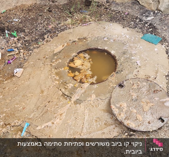 בור ביוב פתוח עם מכסה מונח בצד